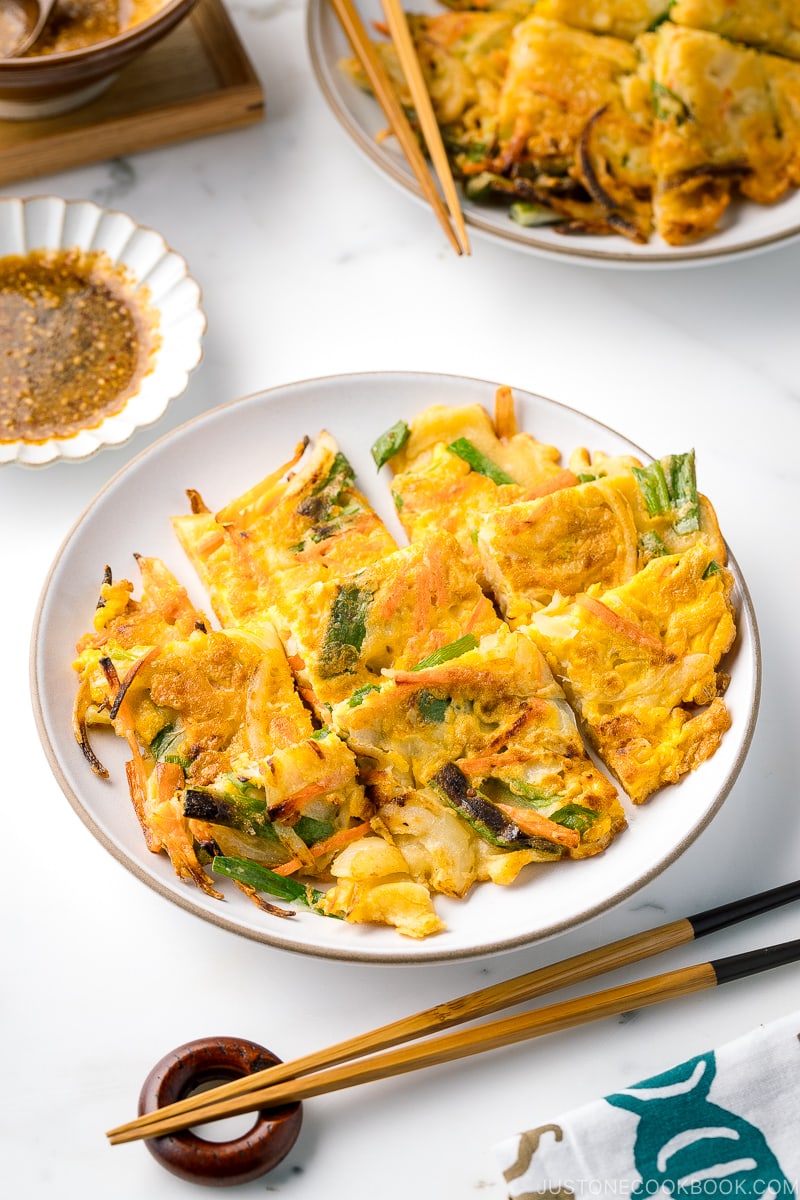 A white plate containing gluten free Korean veggie pancake.