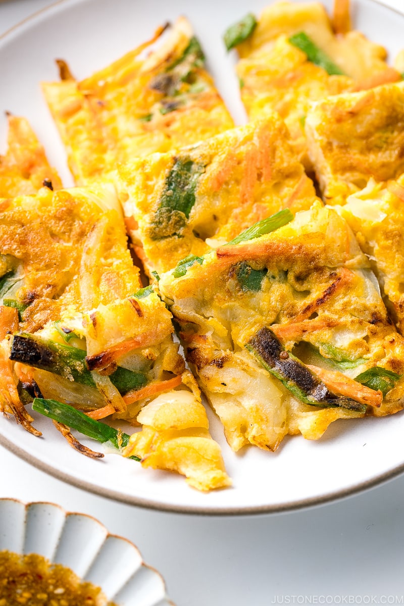 A white plate containing gluten free Korean veggie pancake.