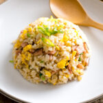 A white ceramic plate containing Japanese fried rice (Yakimeshi).