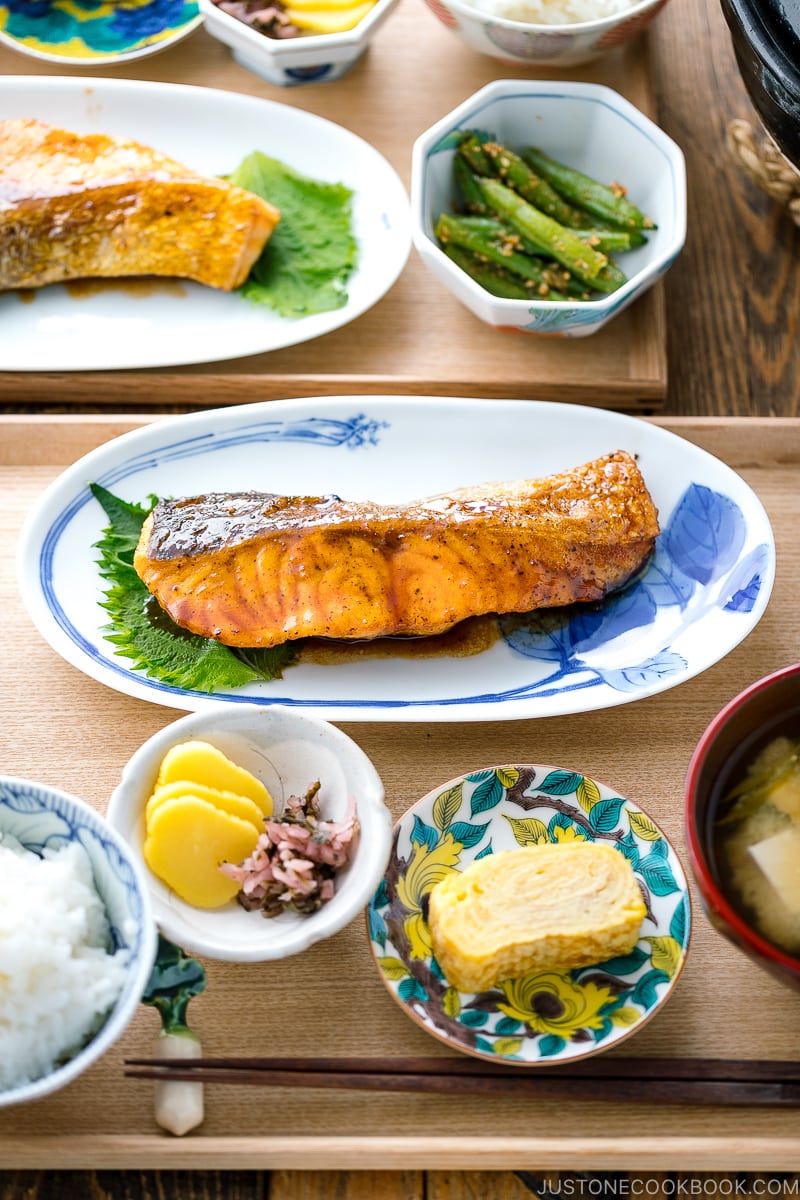 A plate containing Teriyaki Salmon served with steamed rice and miso soup.