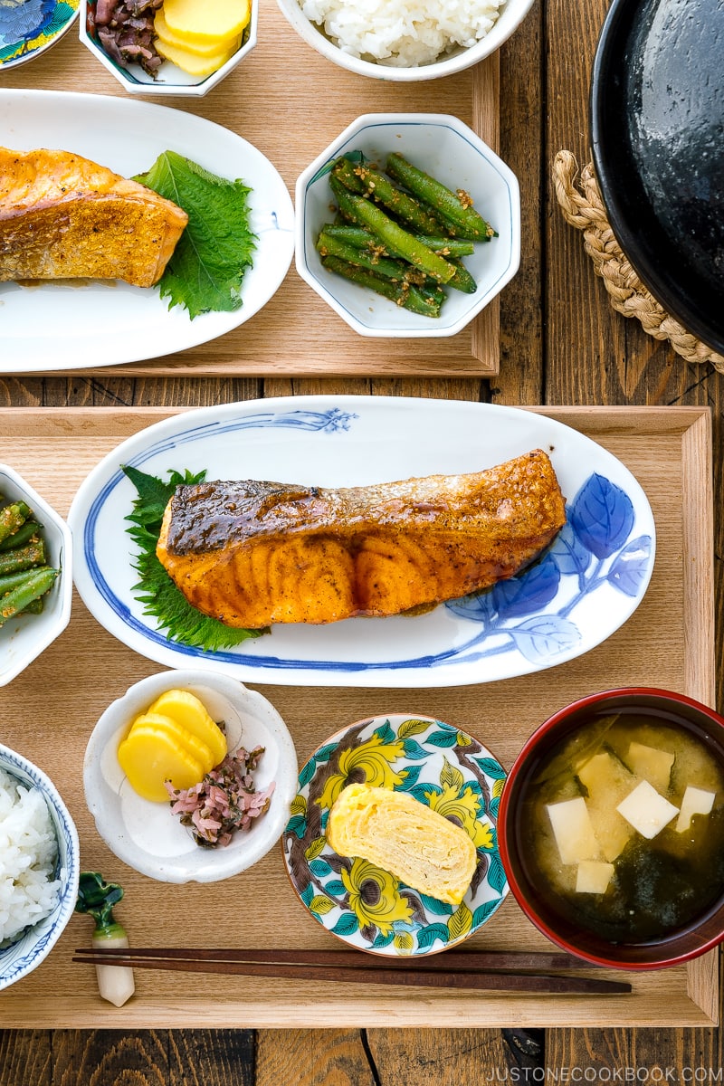 A plate containing Teriyaki Salmon served with steamed rice and miso soup.