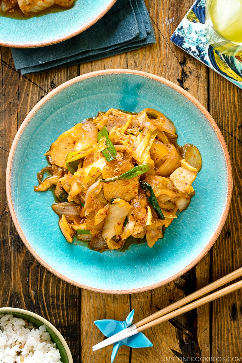 A Japanese ceramic plate containing Pork Kimchi Stir-Fry called Buta Kimchi. It's served with steamed rice.