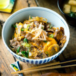 A Japanese donburi bowl containing Tanindon, which is simmered beef and egg over steamed rice.