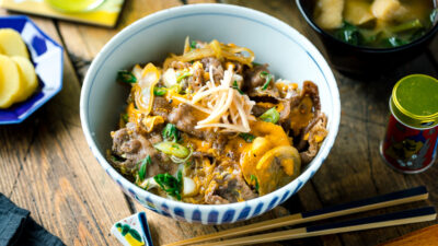 A Japanese donburi bowl containing Tanindon, which is simmered beef and egg over steamed rice.