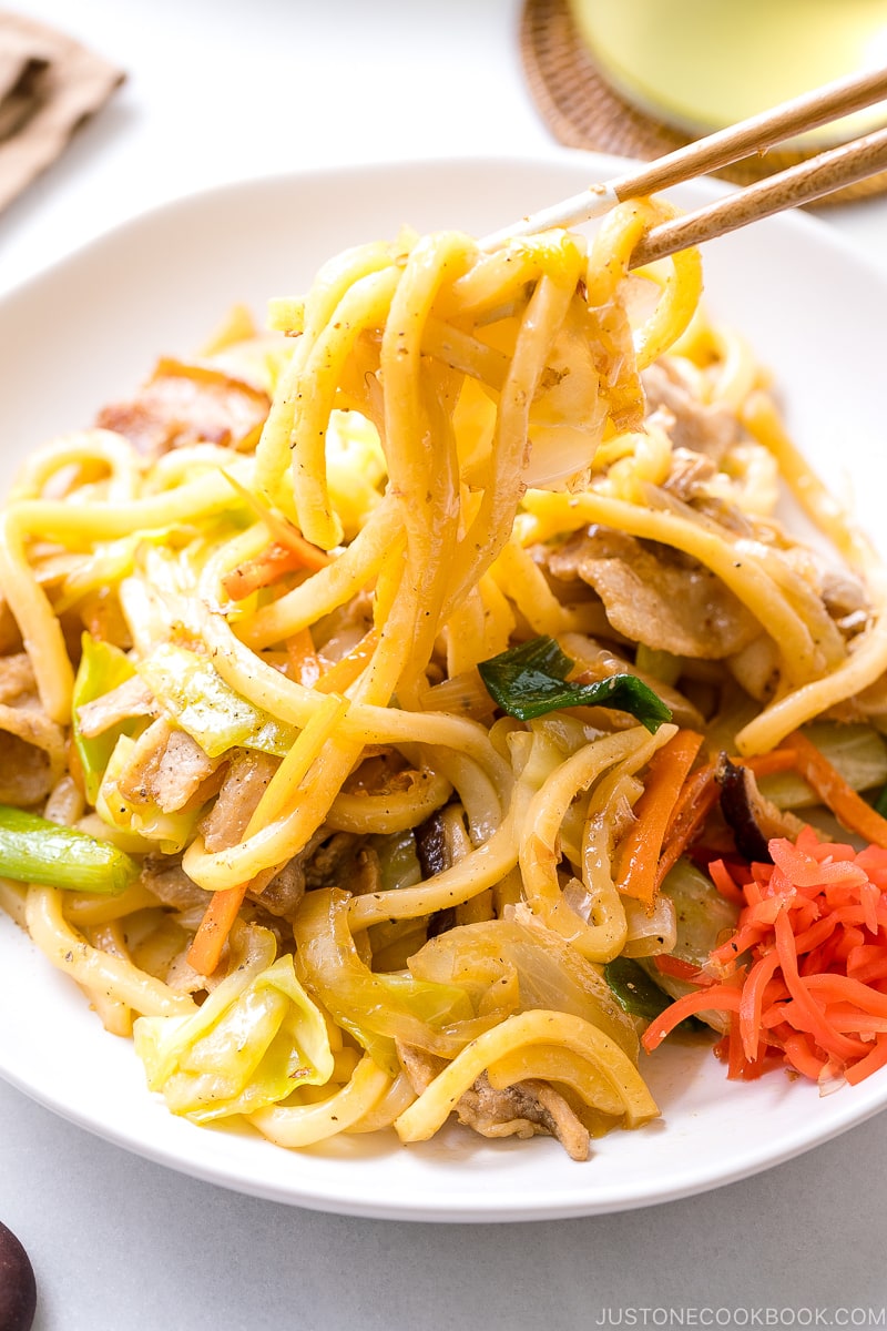 Yaki Udon (Japanese Stir-Fried Udon Noodles) being pulled out with chopsticks.