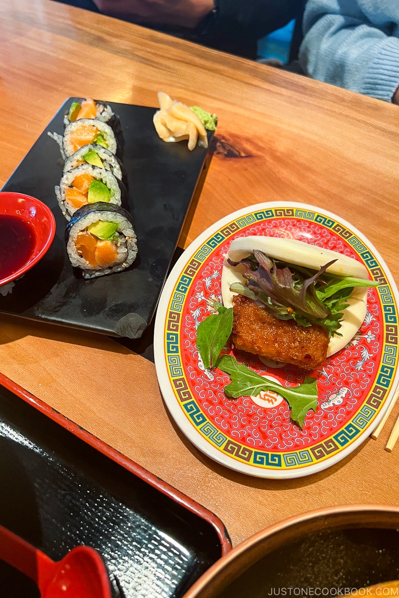 pork belly mantou buns and salmon avocado roll on a wood table