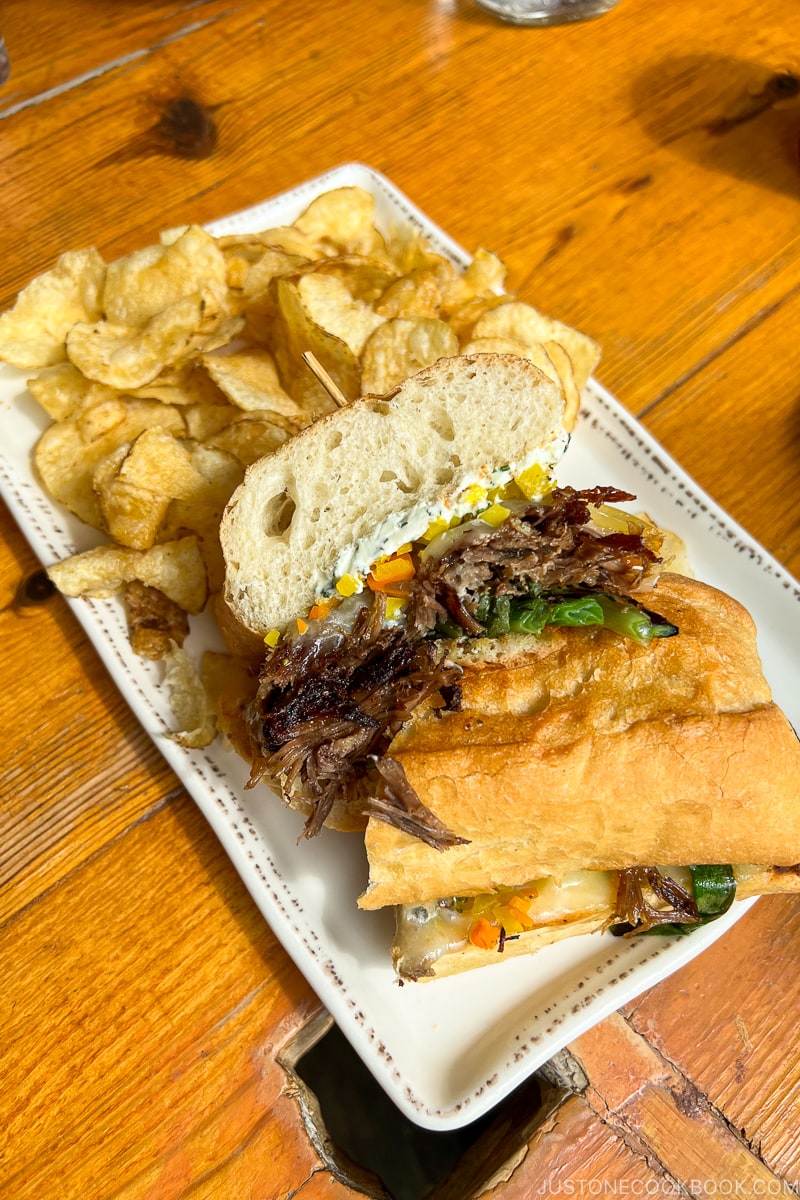 Short Rib Sandwich with chips on a white plate