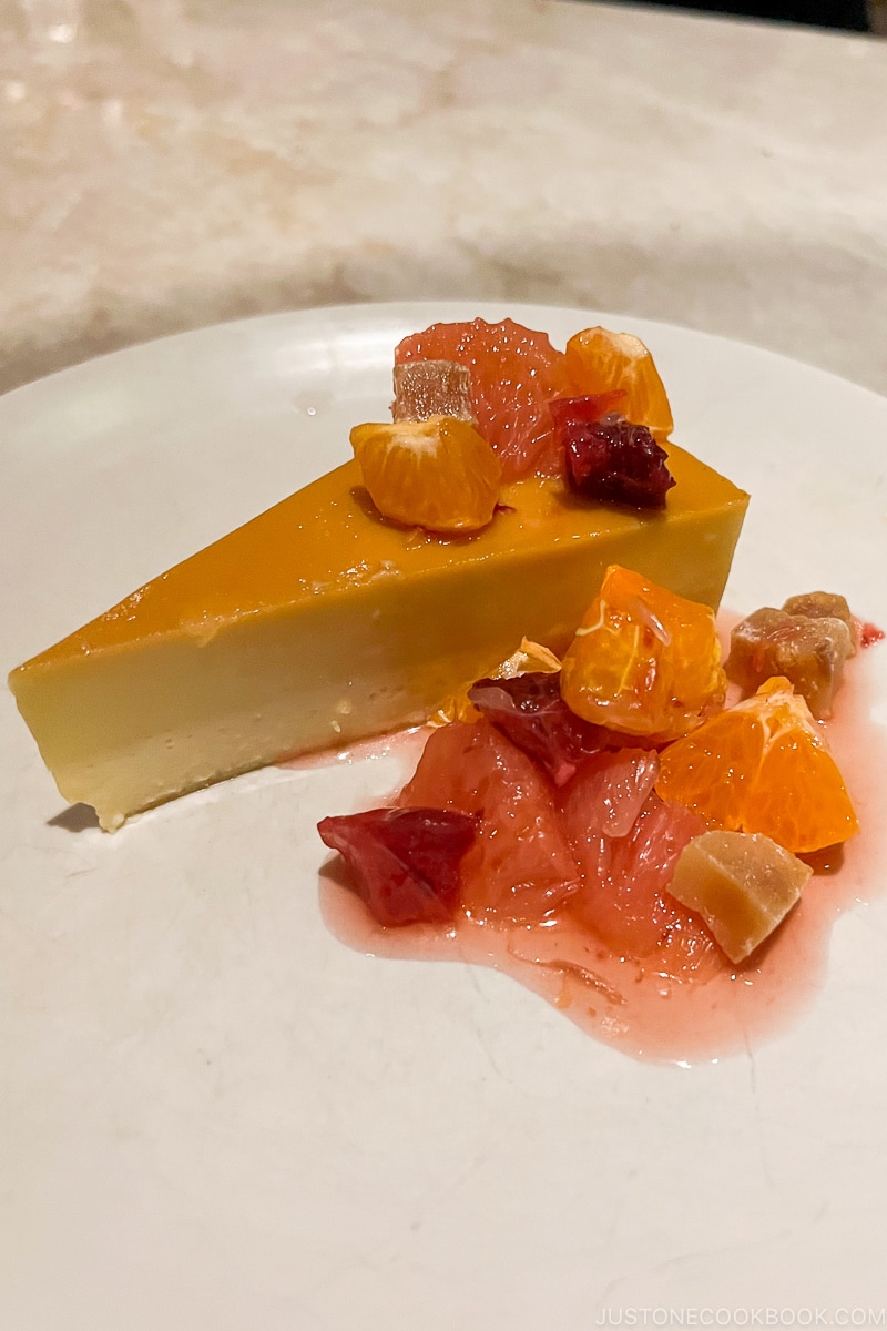 malted vanilla flan next to fruits on a white plate