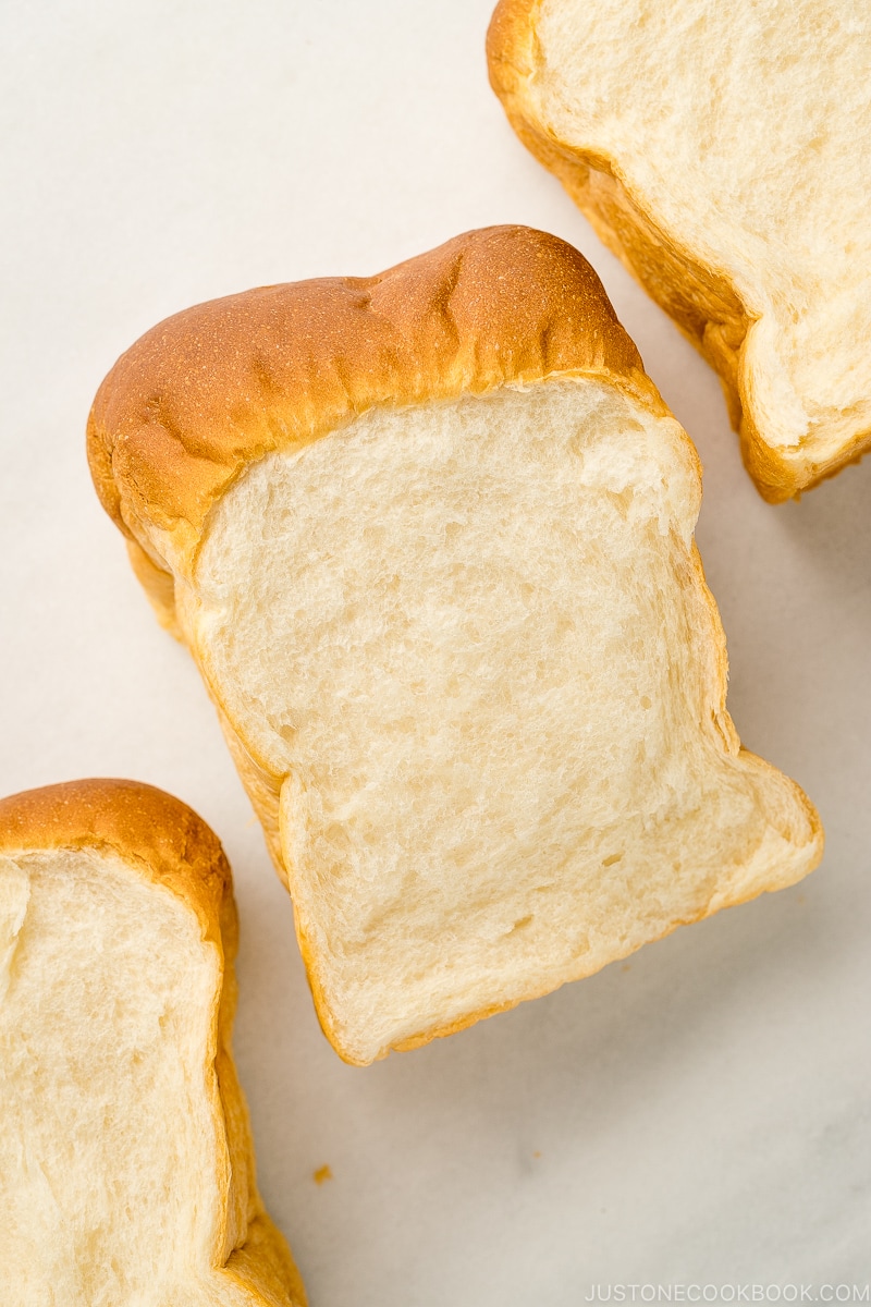 A cross section of Japanese milk bread shown on the marble counterboard.