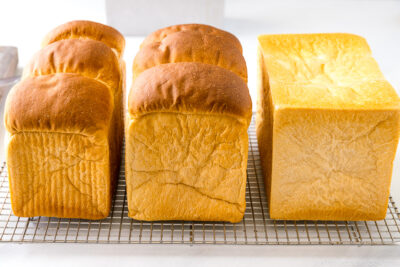 Three loaves of Japanese Milk Bread (Shokupan) on a wire rack.