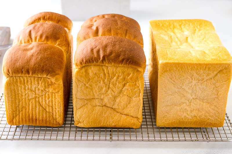 Three loaves of Japanese Milk Bread (Shokupan) on a wire rack.