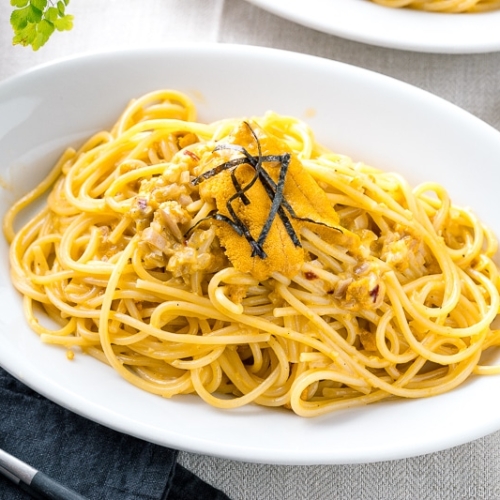 A white oval plate containing Uni Pasta (Japanese sea urchin pastsa).