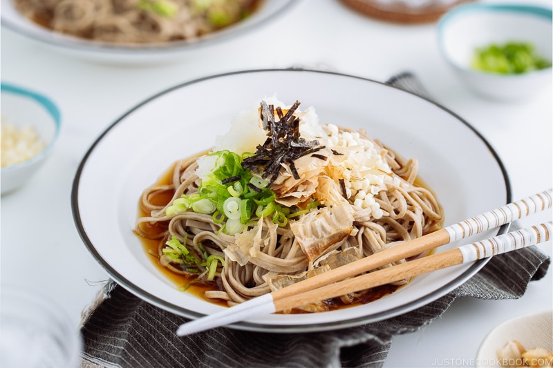 A ceramic bowl containing Oroshi Soba, chilled buckwheat noodles with grated daikon and savory sauce.