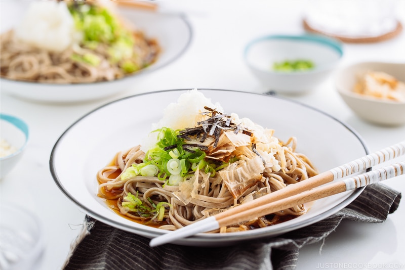 A ceramic bowl containing Oroshi Soba, chilled buckwheat noodles with grated daikon and savory sauce.