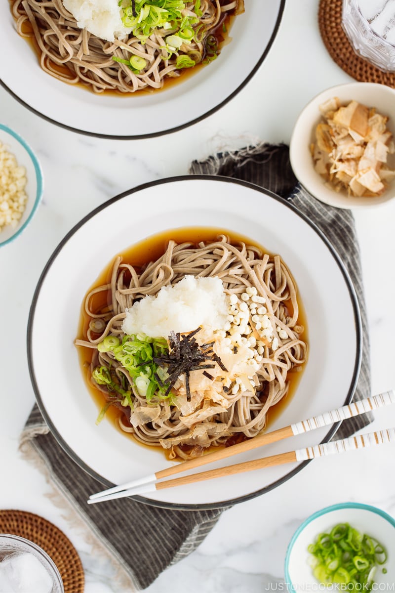 A ceramic bowl containing Oroshi Soba, chilled buckwheat noodles with grated daikon and savory sauce.