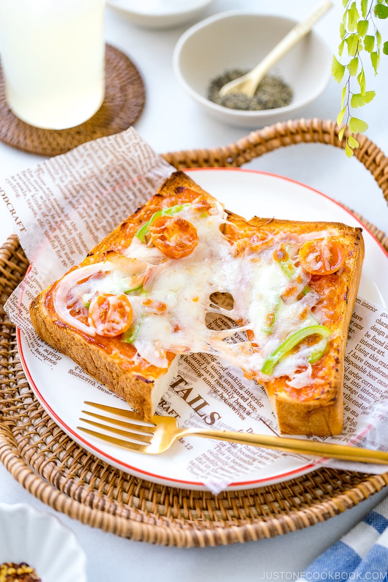 A plate containing Japanese Pizza Toast made with Japanese milk bread, pizza sauce, mozzarella cheese, and various toppings.