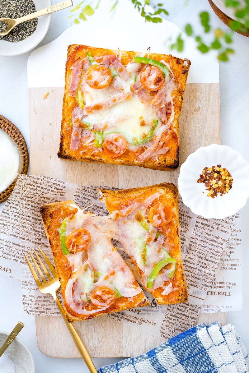 A plate containing Japanese Pizza Toast made with Japanese milk bread, pizza sauce, mozzarella cheese, and various toppings.