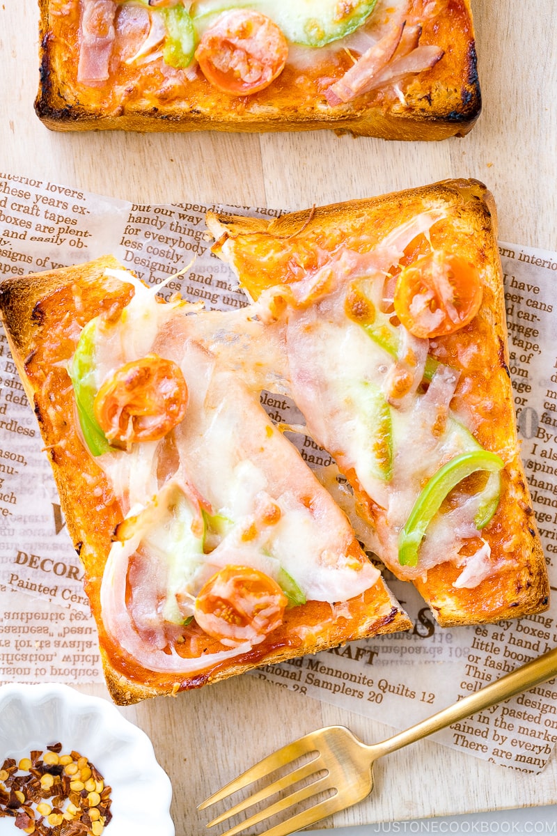 A plate containing Japanese Pizza Toast made with Japanese milk bread, pizza sauce, mozzarella cheese, and various toppings.