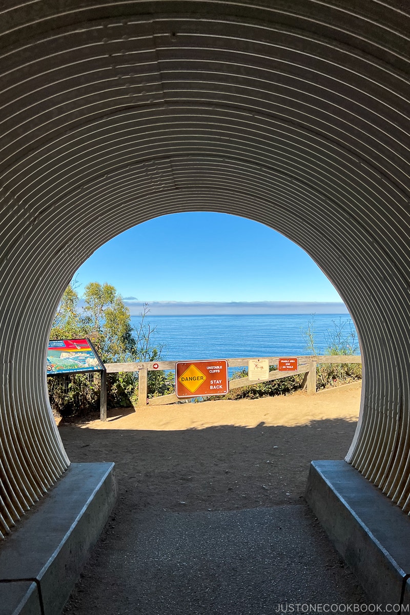 a tunnel leading out to a cliff by the ocean