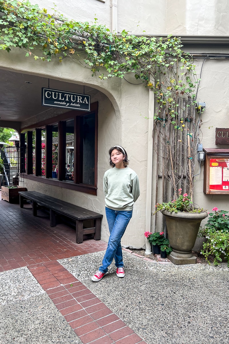 a girl standing in front of Cultura Comida y Bebida Restaurant Carmel