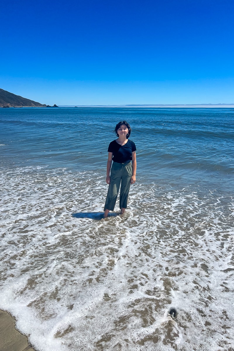 a girl standing in the ocean