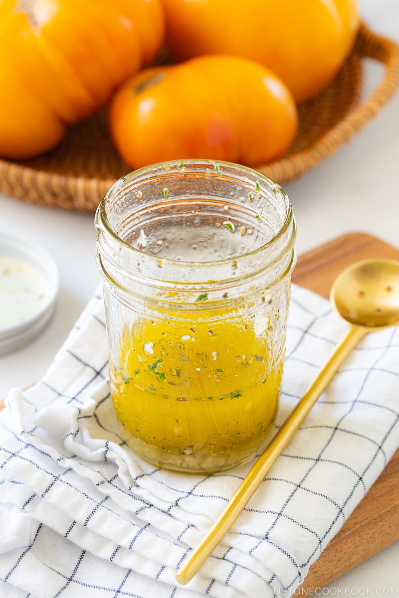 A mason jar containing the dressing for Heirloom Tomato Salad