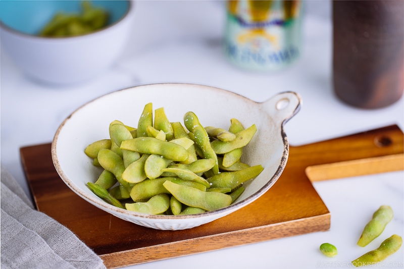 A ceramic bowl containing perfectly cooked and salted edamame.