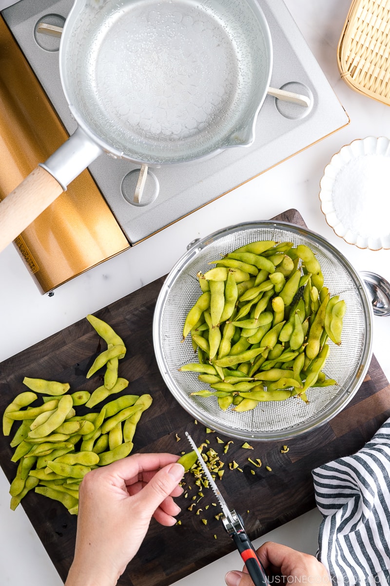 Snipping off the edges of fresh edamame.