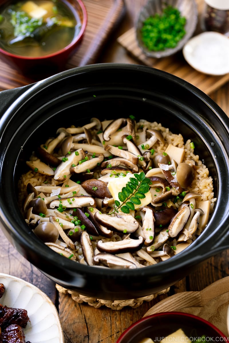 A Hario donabe (Japanese clay pot) containing Japanese Mushroom Rice topped with butter, chives, and sea salt flakes.