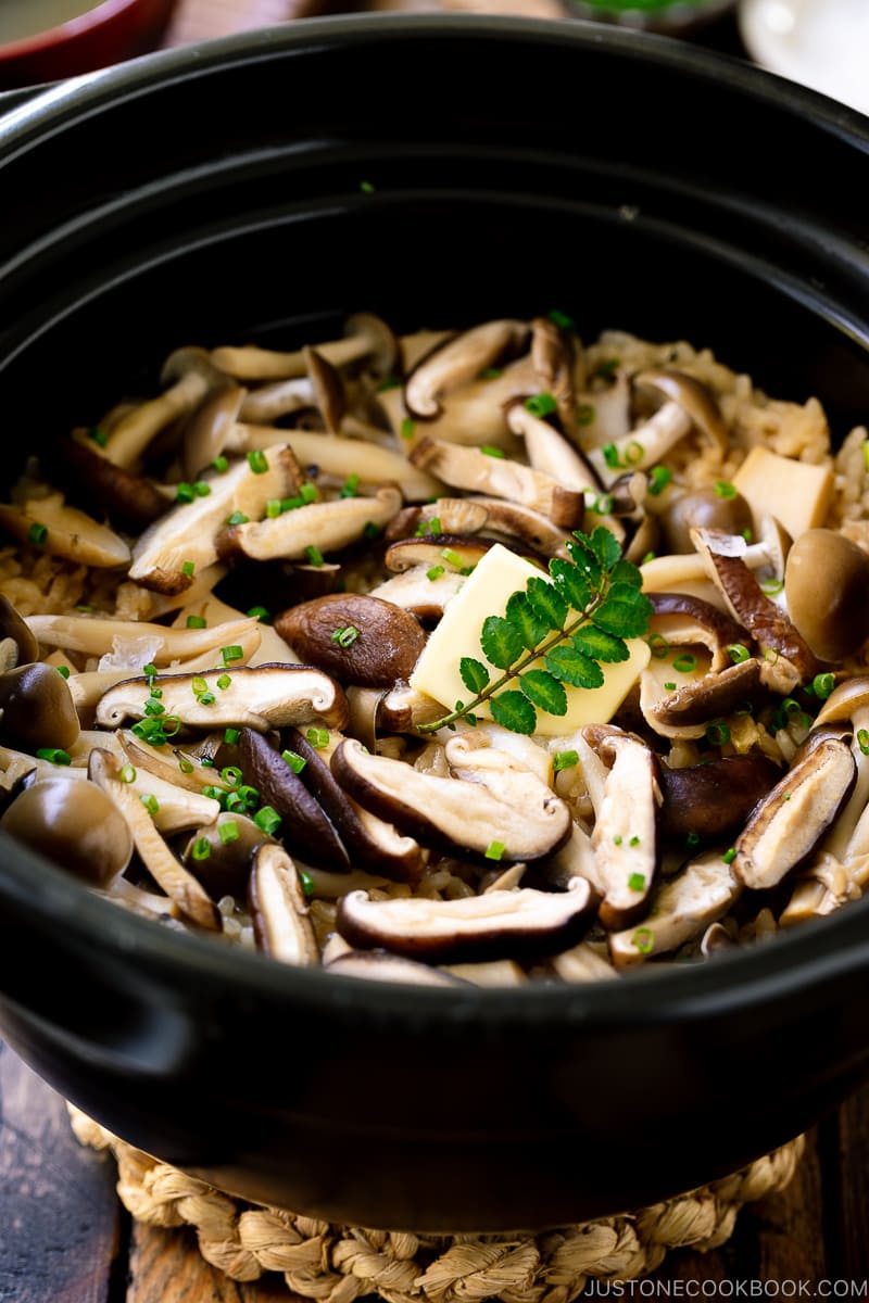 A Hario donabe (Japanese clay pot) containing Japanese Mushroom Rice topped with butter, chives, and sea salt flakes.