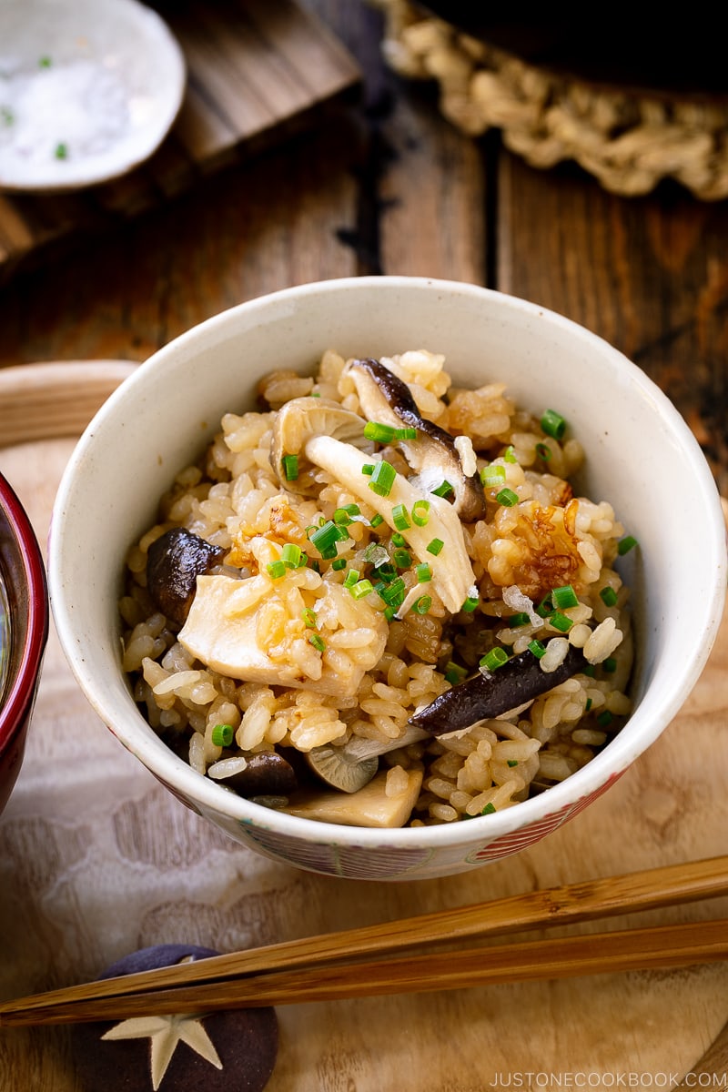 A Japanese rice bowl containing Japanese Mushroom Rice topped with butter, chives, and sea salt flakes.