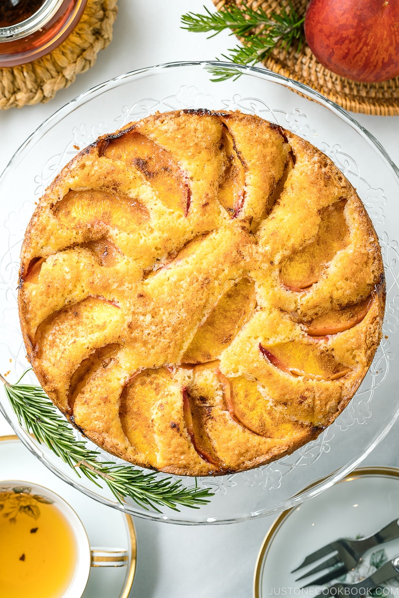 A whole Peach Cake on the glass cake stand.