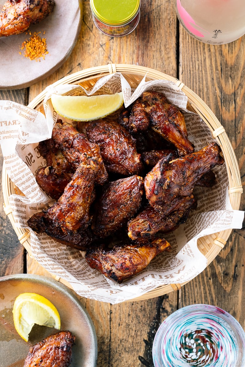 A bamboo basket containing smoked salt and pepper chicken wings.