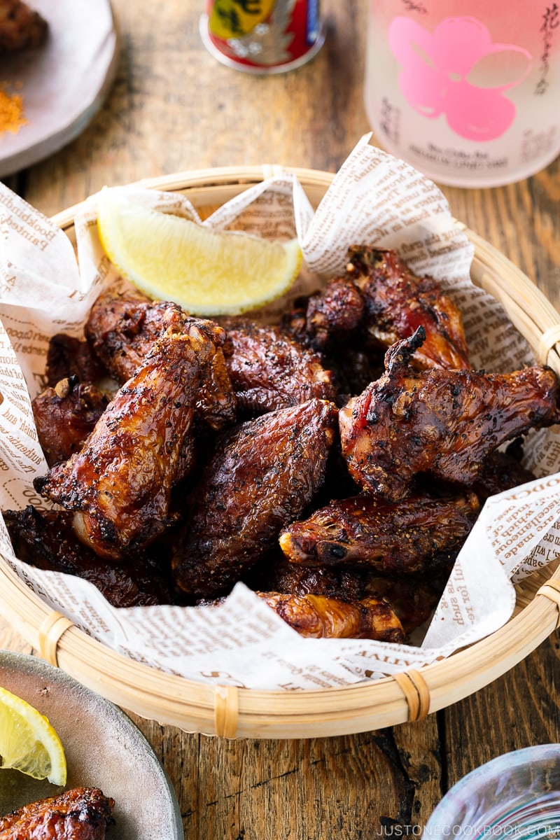 A bamboo basket containing smoked salt and pepper chicken wings.