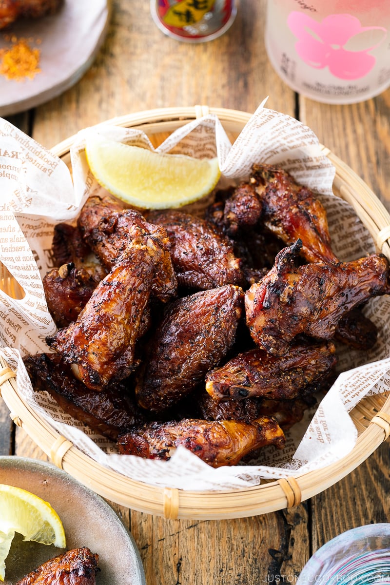A bamboo basket containing smoked salt and pepper chicken wings.