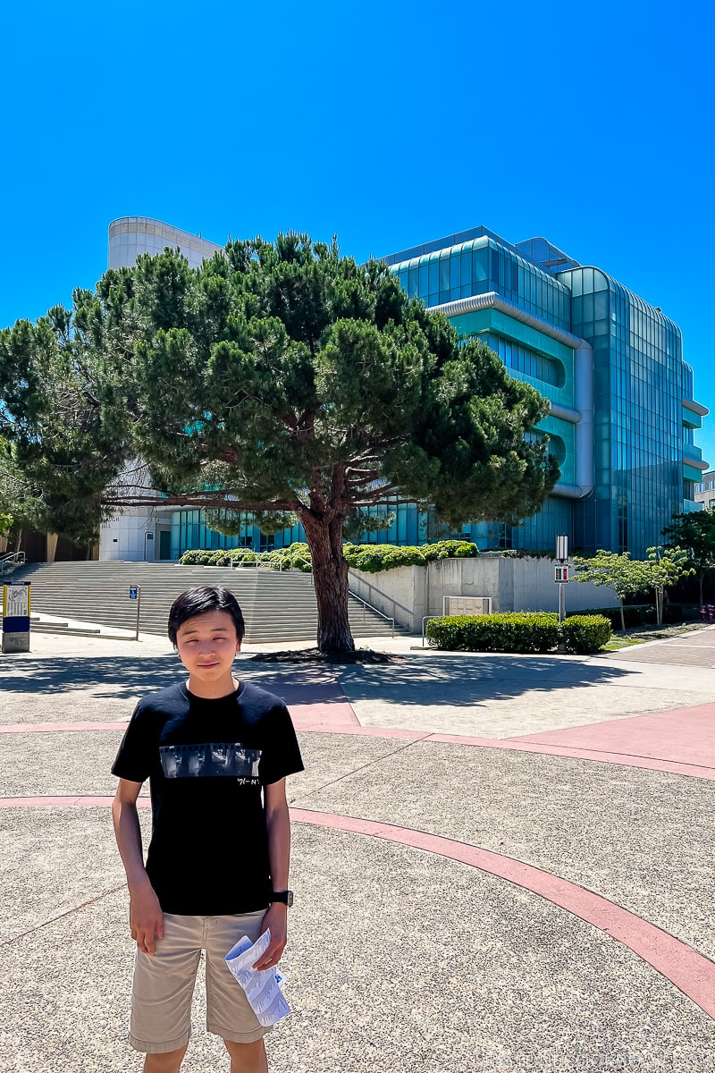 a boy standing in front of a school building