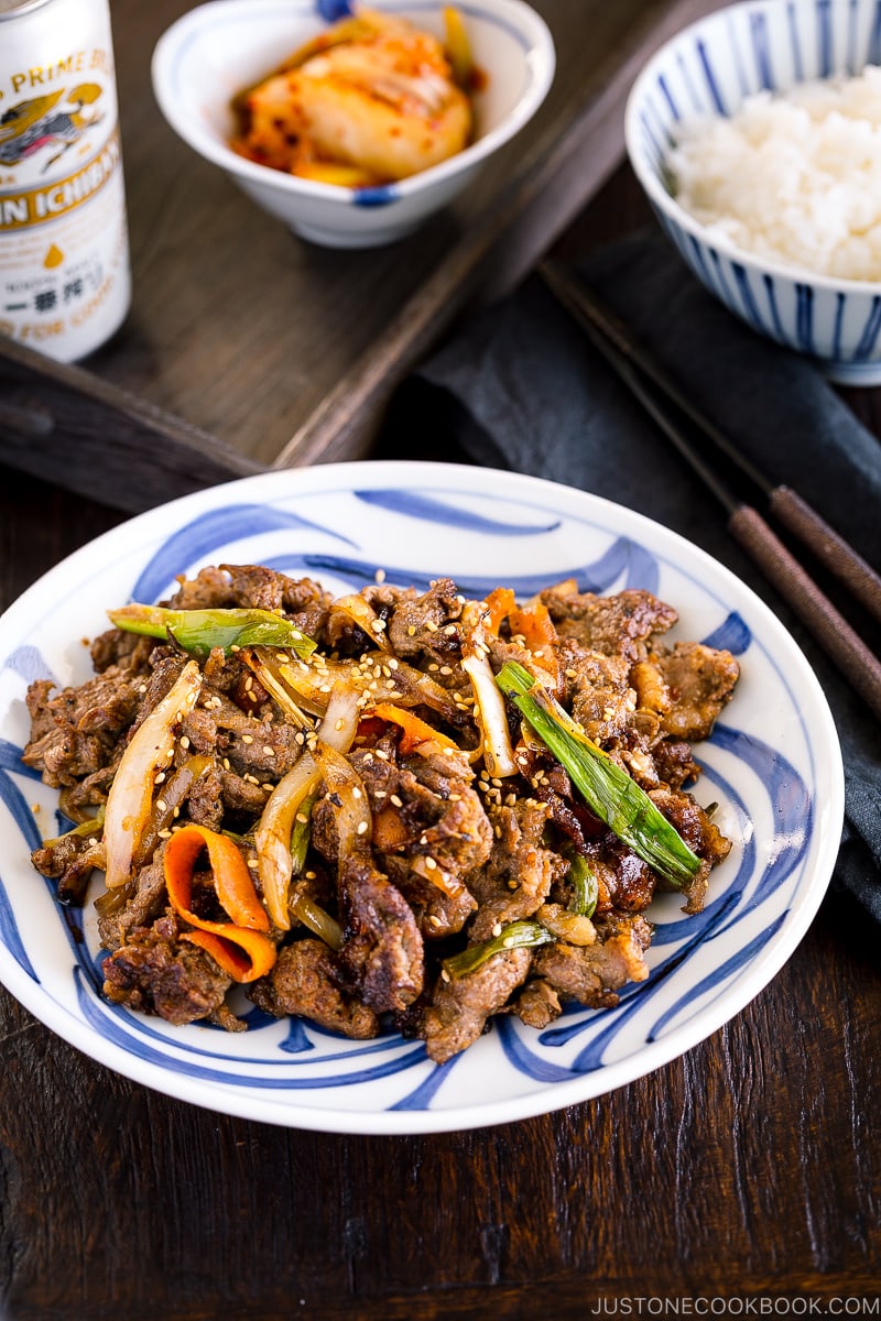 A blue and white Japanese plate containing Bulgogi (Korean grilled beef).