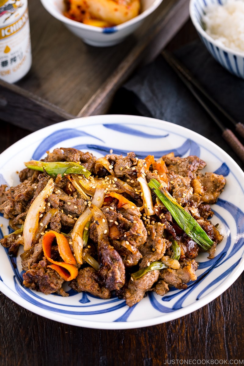 A blue and white Japanese plate containing Bulgogi (Korean grilled beef).