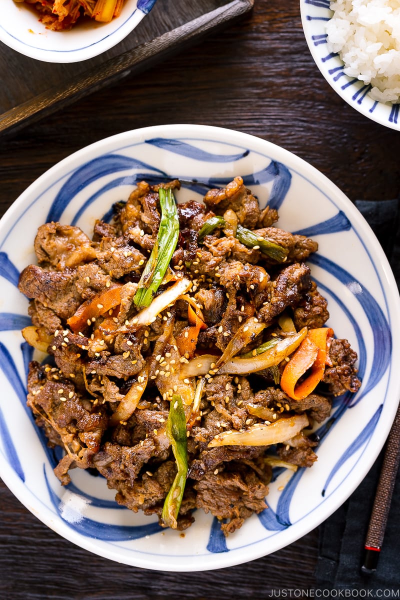 A blue and white Japanese plate containing Bulgogi (Korean grilled beef).
