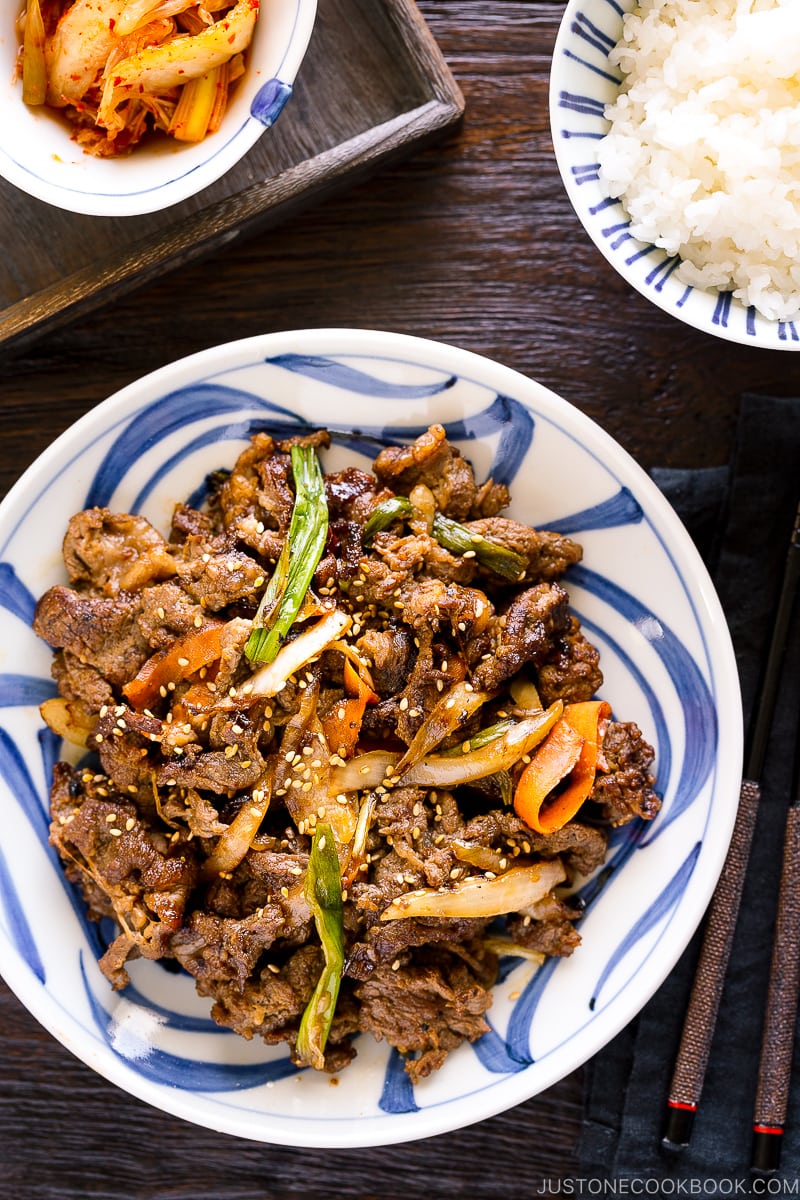 A blue and white Japanese plate containing Bulgogi (Korean grilled beef).