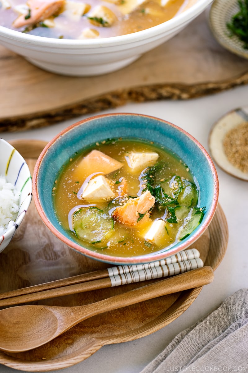 A cobalt blue ceramic bowl containing cold miso soup (hiyajiru) with tofu, cucumber, and salmon).