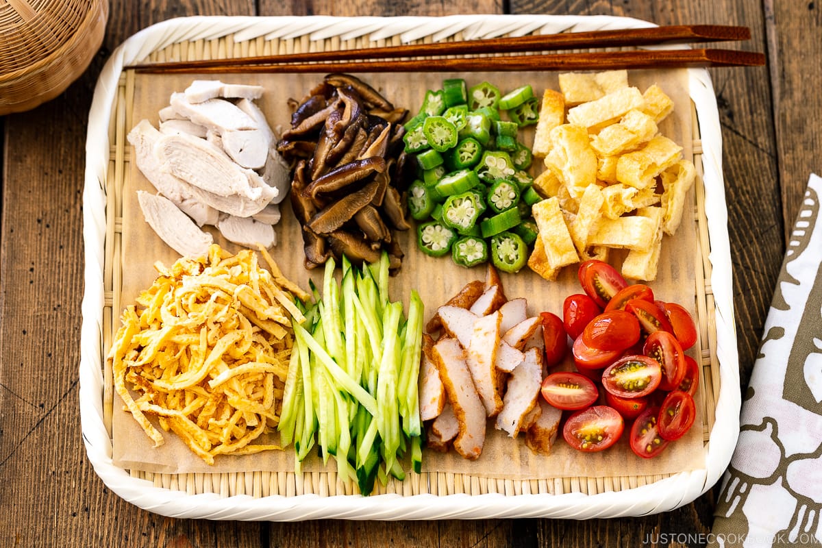 A bamboo tray containing various somen noodle toppings.