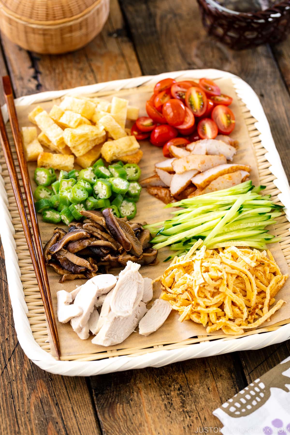 A bamboo tray containing various somen noodle toppings.