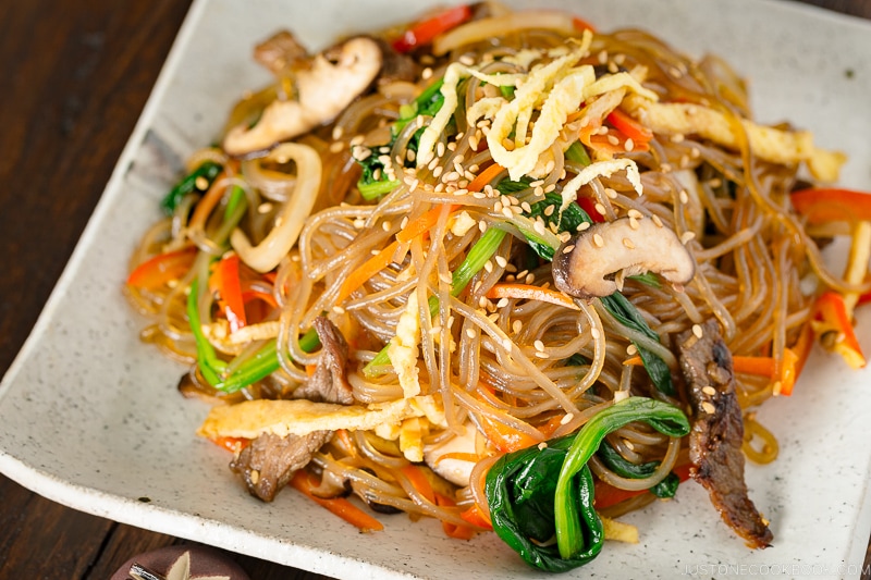 A white square plate containing Japchae (Korean Stir-Fried Noodles)