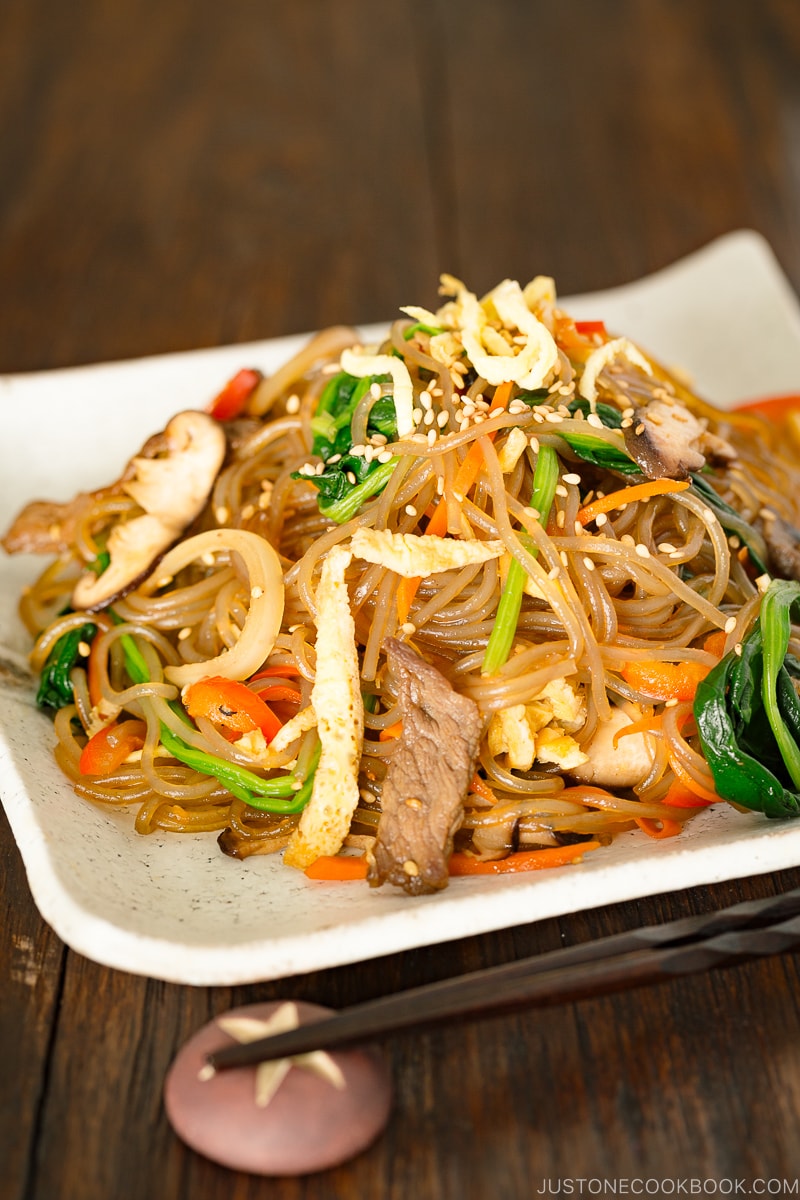 A white square plate containing Japchae (Korean Stir-Fried Noodles)