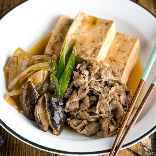 A white plate containing Japanese simmered beef and tofu (niku dofu).