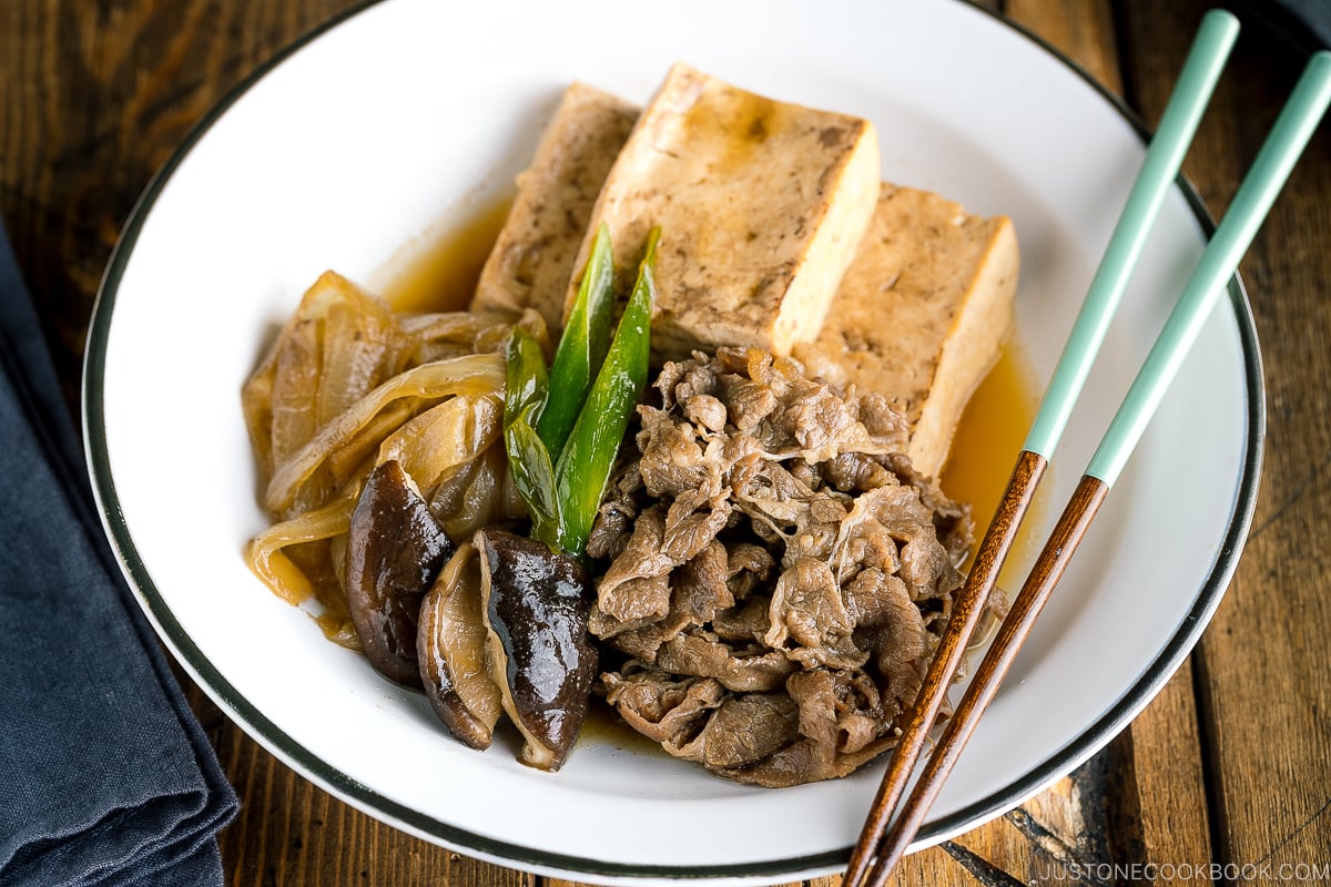 A white plate containing Japanese simmered beef and tofu (niku dofu).