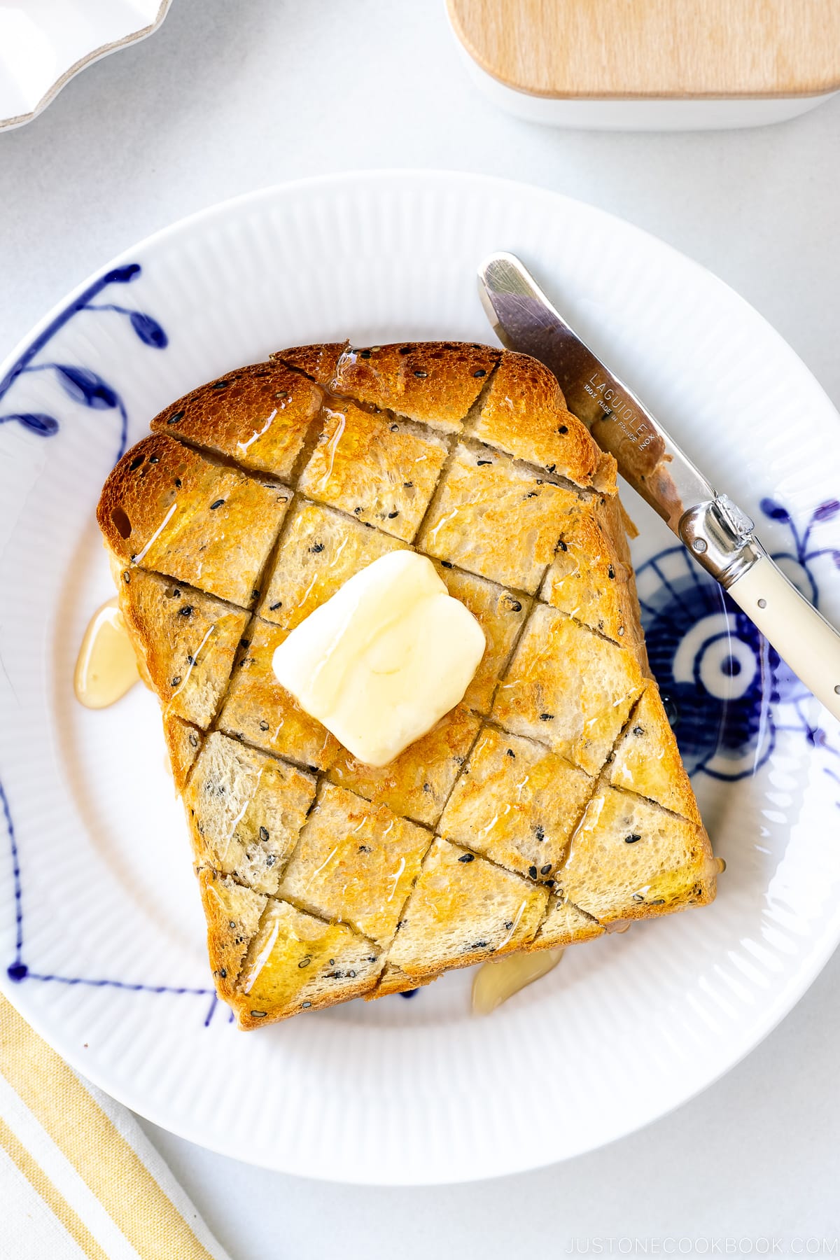 A toasted Black Sesame Shokupan with butter and honey on top.