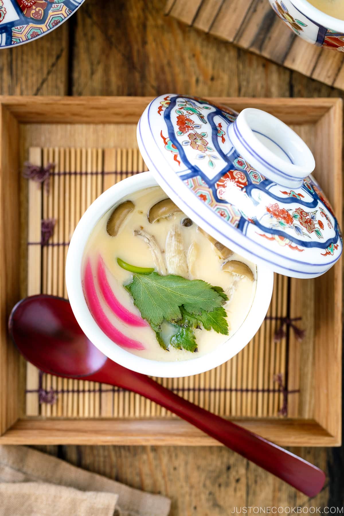 A special Japanese chawanmushi cup containing savory steamed custard filled with kamaboko fish cake, chicken, and mushroom.