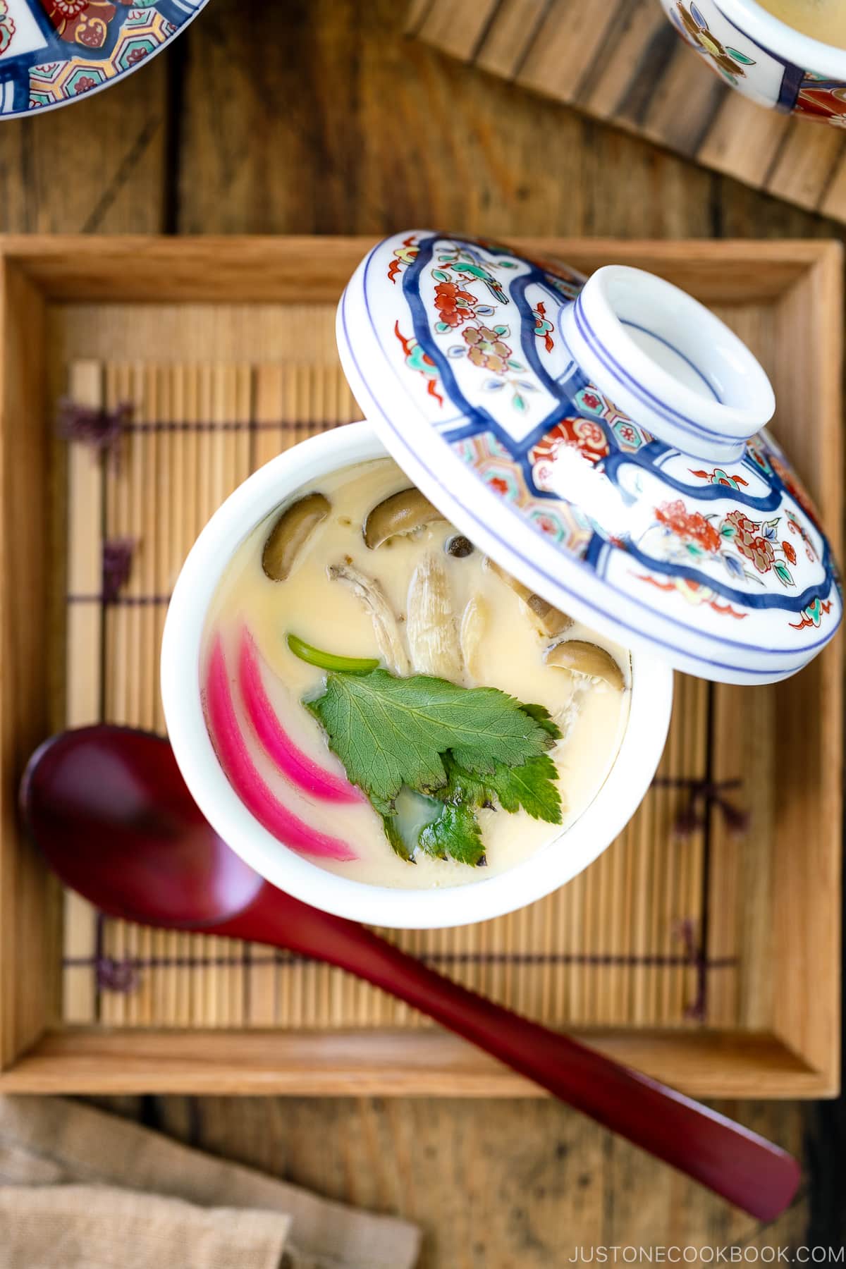 A special Japanese chawanmushi cup containing savory steamed custard filled with kamaboko fish cake, chicken, and mushroom.